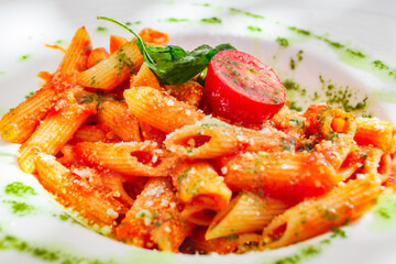 Pasta penne with tomato sauce cheese and basil, close-up, selective focus