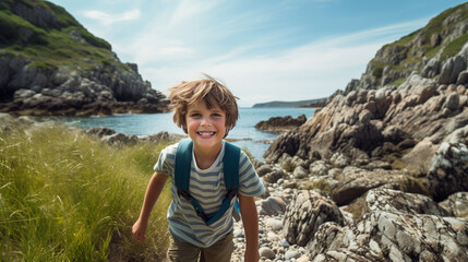 boy hiking along rocky sea coast at summer - obrazy, fototapety, plakaty