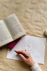 Hands of a woman writing an astrological chart