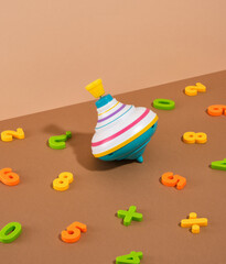 Cheerful nice spinning top and colored numbers scattered. Toys collection for small children.