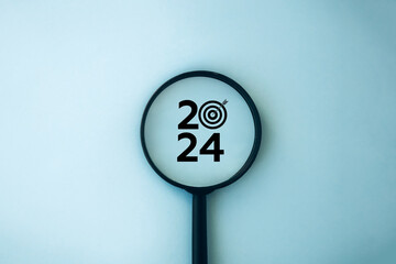 Happy new year 2024 business concept. 2024 number with target icon inside the magnifying glass on...