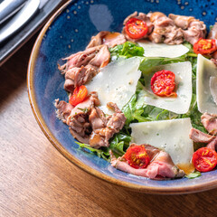 Salad with roast beef, rucola and vegetables.