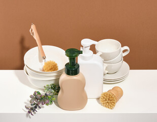 Set of clean washed dishes and cups. Detergent dispensers and environmentally friendly dishwashing brushes.