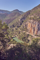 panoramic of a canyon in the mountains with a reservoir and a pier on the river