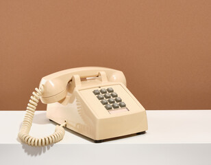 A vintage phone stands on a white table. Vintage and retro fashion style.