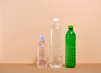 Water in plastic bottles on a beige background. Water balance.