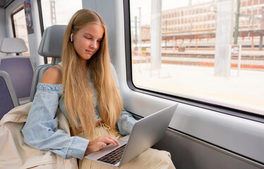 Girl using laptop computer in train