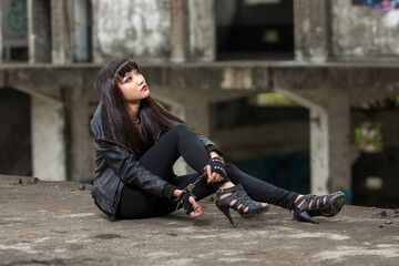 Asian woman in emo goth clothes at an abandoned building - obrazy, fototapety, plakaty