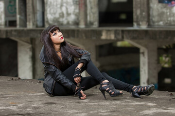 Asian woman in emo goth clothes at an abandoned building - obrazy, fototapety, plakaty