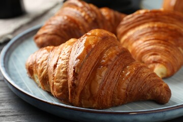 Delicious fresh croissants on dark table, closeup