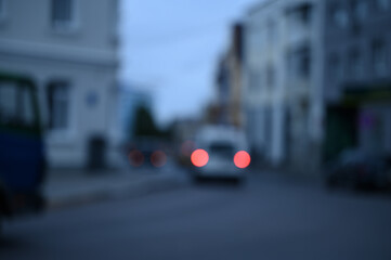 evening city street in the light of headlights and lanterns blur background