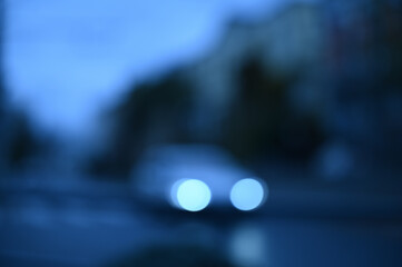 evening city street in the light of headlights and lanterns blur background