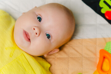 Portrait of a cute baby lying on the bed at home.