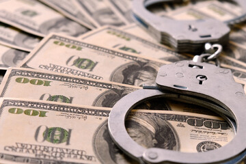 Cash in US Dollars, Real Handcuffs. The Concept of Arrest, Corruption, Bail, Crime, Bribery or...