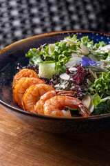 Warm salad with avocado, shrimps, tomatoes and herbs in cup.