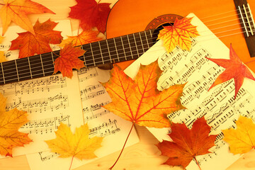 autumn melody, acoustic guitar, music paper and dry fallen maple leaves - 672642231