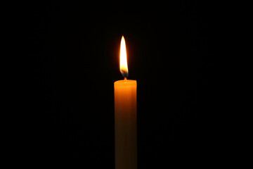 burning candle on a black background - 672642458