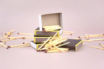 A box of matches placed next to a toy red fire extinguisher against a light background.