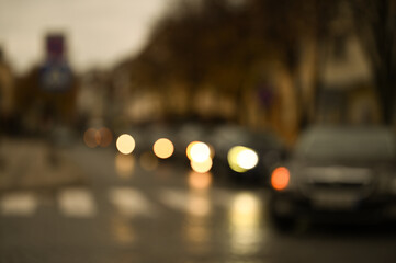 evening city street in the light of headlights and lanterns blur background