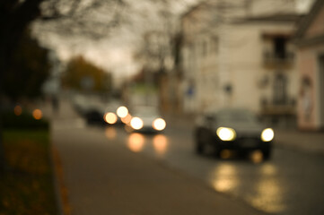 evening city street in the light of headlights and lanterns blur background