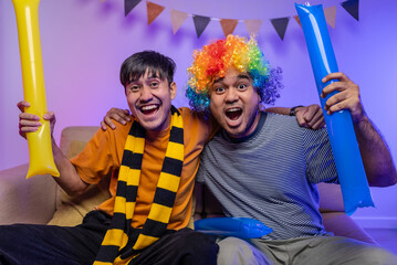 Happy asian man friends watching soccer games world cup competition on television together at home...