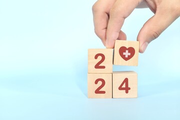 Year 2024 health goal and healthcare priority concept. Wooden blocks on blue background with icon.	
