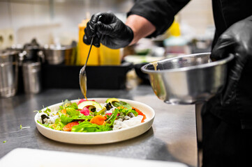 chef hands cooking salad with vegetables on kitchen