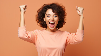 
Photo of cheerful overjoyed funny woman raise fists in victory see big bargains in phone isolated on beige color background