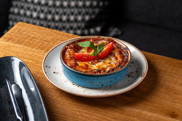 Traditional Italian lasagna with tomato and meat sauce baked with cheese. Fragment with a blurred background.