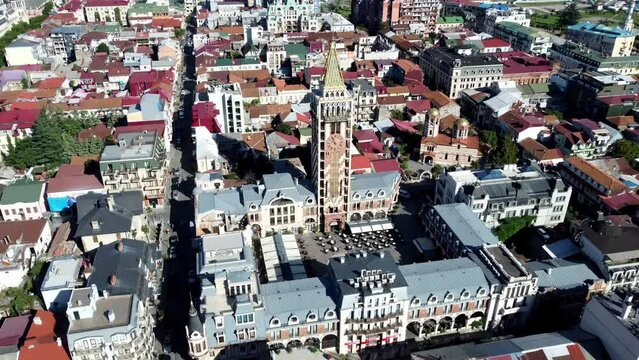 Drone footage of Batumi's Piazza Square and its clock tower, with an expansive view of the old city from above.
