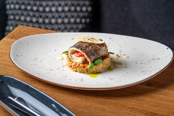 Trout with bulgur and vegetables in white bowl