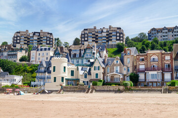 Trouville coastline architecture along the sandy beach. Famous resort and fishermen village in...