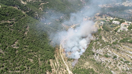 Fire on a mountain with smoke in a sunny day. Natural disaster