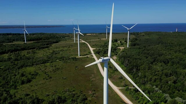 Powerful Wind turbine farm for energy production. Wind Power Turbines Generating Clean Renewable Energy for Sustainable Development. Offshore wind turbines in sea against blue sky. Estonia, Paldiski