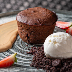 Lava cake with vanilla sauce with fresh strawberries, ice-cream ball