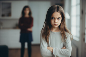 Unhappy, moody and angry little girl standing with arms crossed and looking upset while ignoring her mom, Upset, naughty and problem daughter or child and her angry or disappointed mother at home