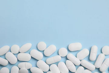 Fotobehang Many pills on light blue background, flat lay. Space for text © New Africa