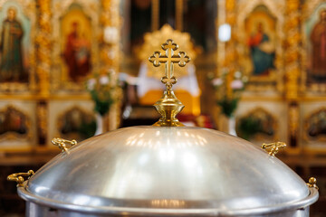 Aluminium church font, large bowl, with golden cross and saint water for the baptism of babies in Orthodox Church temple, Christening ceremony.Concept of rituals, sacraments of the Christian religion. - obrazy, fototapety, plakaty