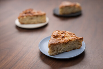 Portions of of charlotte apple pie on a saucers on walnut table