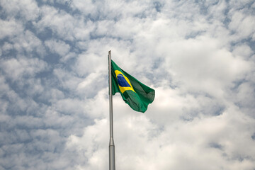 Uma Bandeira do Brasil tremulando ao vento em um dia nublado.