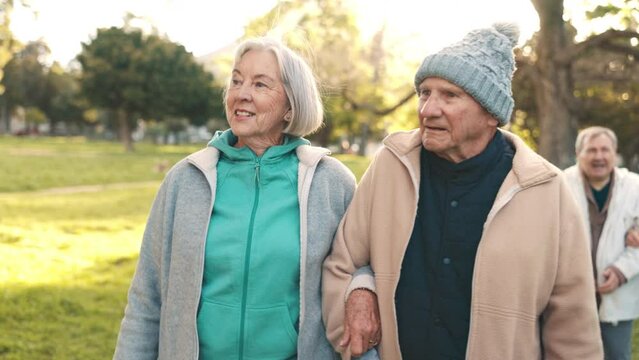 Senior couple, walking and talking in park together for morning exercise, bonding and happy conversation. Smile, nature and old people, men and women in garden with discussion and sunshine in trees.
