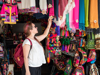 Mujer turista mirando los artículos de una tienda de recuerdos en Salta, Argentina