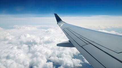 Fototapeta na wymiar Wing of modern aircraft flying in cloudy blue sky during trip. 