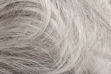 Blond hair close-up as a background. Women's long blonde hair. Beautifully styled wavy shiny curls....