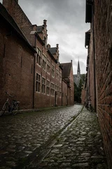 Deurstickers residential houses in the Groot Begijnhof historic district of Leuven in Belgium on grey rainy day. Atmospheric street photography showing old stone streets with pretty red brick buildings © drew
