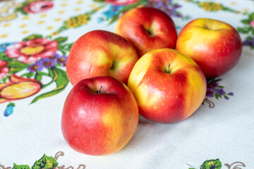 beautifully ripe apples lying on an embroidered tablecloth, healthy and tasty fruit, natural food