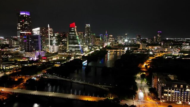 Timelapse of the traffic on the streets of a city with illuminated skyscrapers in the background