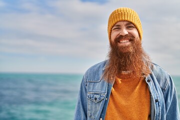 Young redhead man smiling confident standing at seaside