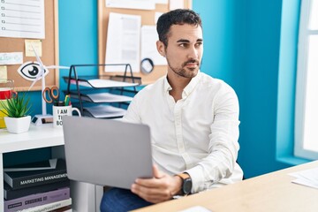 Obraz premium Young hispanic man business worker using laptop working at office