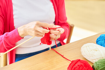 Obraz na płótnie Canvas 毛糸の編み物を楽しむ女性の手元